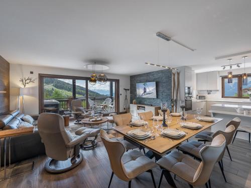 une salle à manger et un salon avec une table et des chaises dans l'établissement Appartement moderne avec jacuzzi extérieur et terrasse à Courchevel - FR-1-563-106, à Courchevel