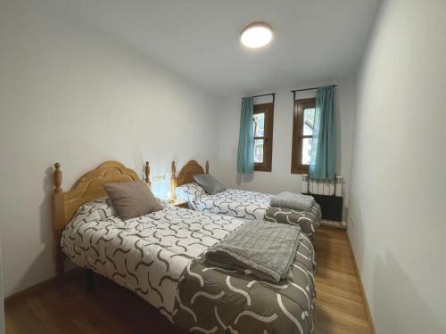 twee bedden in een slaapkamer met blauwe gordijnen bij B42 - Apartamento en Av Los Tilos - Villmor in Benasque
