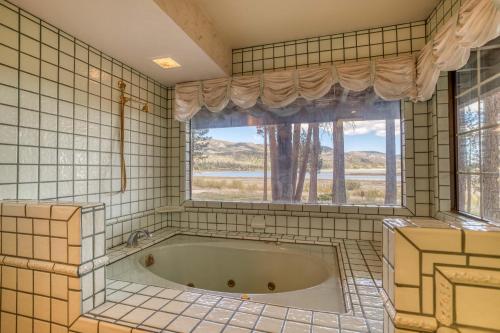 een bad in een betegelde badkamer met een raam bij 036 - Eye of the Eagle in Big Bear Lake