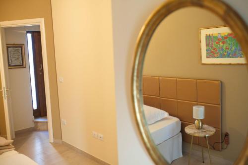 a mirror in a room with a bed and a table at Dimora Offidius in LʼAquila