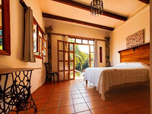 a bedroom with a bed and a large glass door at Posada La Vereda in Cuetzalán del Progreso