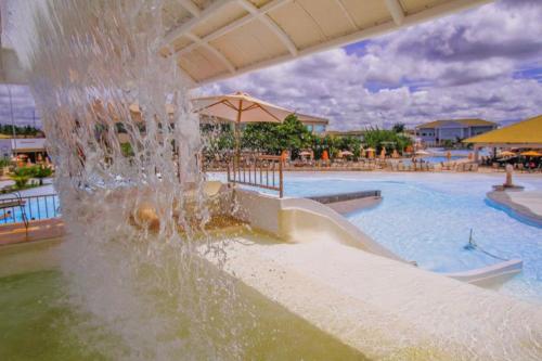 a water fountain in a swimming pool with a slide at Lacqua Diroma Parque - I - II -III - IV - V in Caldas Novas