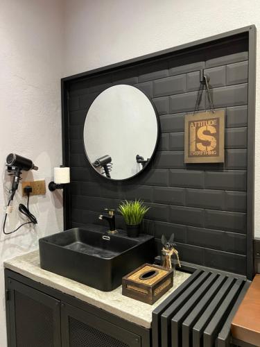 a black bathroom with a sink and a mirror at ZUSCH STUDIO in Pantai Cenang