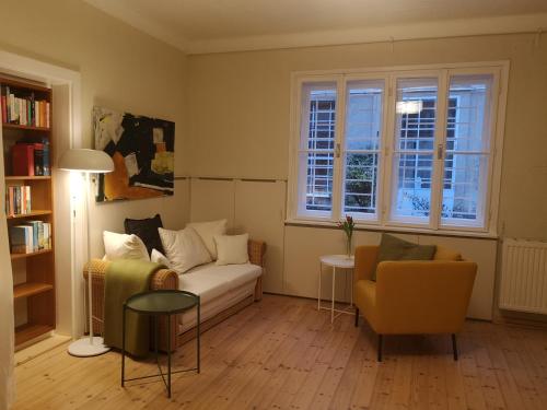 sala de estar con sofá y silla en Das Kleine Haus - Vintage-Apartment im Innenhof, en Viena