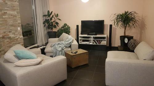 ein Wohnzimmer mit 2 Sofas und einem TV in der Unterkunft Calme chambre Maya in Lyon