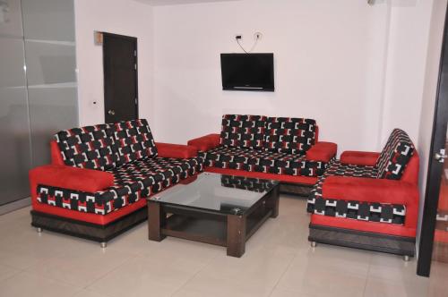 a living room with three chairs and a coffee table at Hotel San José Plaza in Bucaramanga