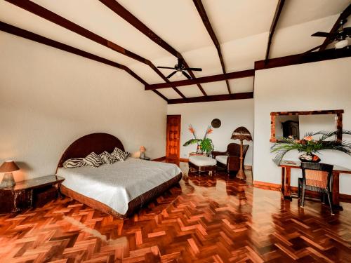 1 dormitorio con 1 cama y suelo de madera en Canal Grande Lodge, en Piedades