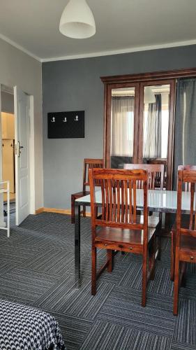 a dining room with a table and wooden chairs at Apartament ALMONIA in Wrocław