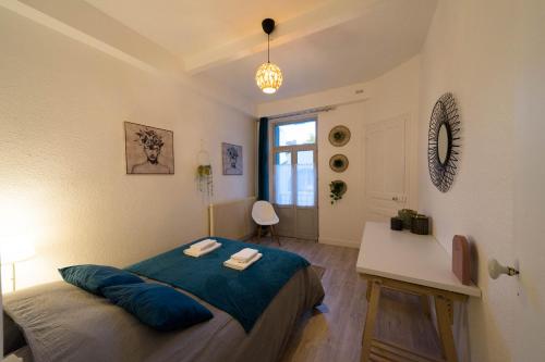 um quarto com uma cama, uma mesa e uma janela em AppartUnique - Chez Klein em Vichy