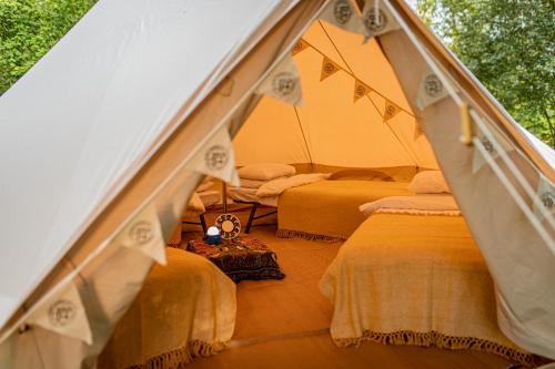 a room with three beds in a tent at Nine Yards Bell Tents @ The Open in West Kirby