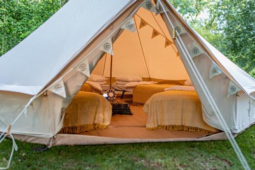 namiot z trzema łóżkami w trawie w obiekcie Nine Yards Bell Tents @ The Open w mieście West Kirby