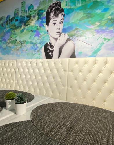 a painting of a woman on a wall next to a table at Lisbon City Hollywood Hotel by City Hotels in Lisbon