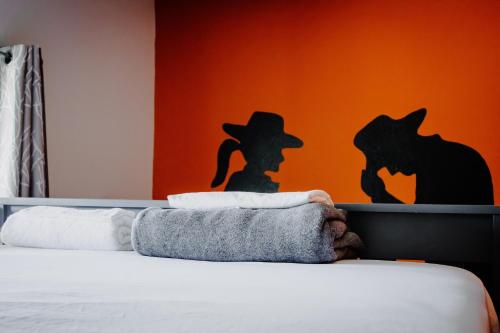 a bedroom with a bed with a black and orange wall at Wanderstay Houston Hostel in Houston