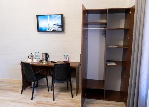 ein Esszimmer mit einem Tisch und einem Bücherregal in der Unterkunft NEST INN in Taschkent