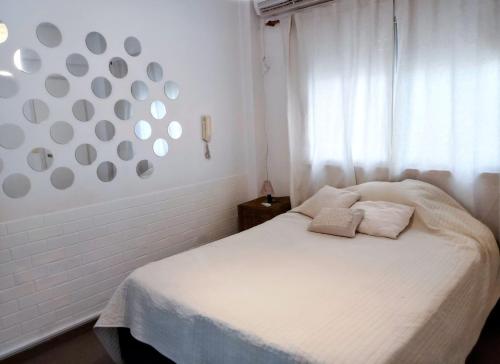 a bedroom with a white bed and a window at Recoleta Loft con Terrazas in Buenos Aires