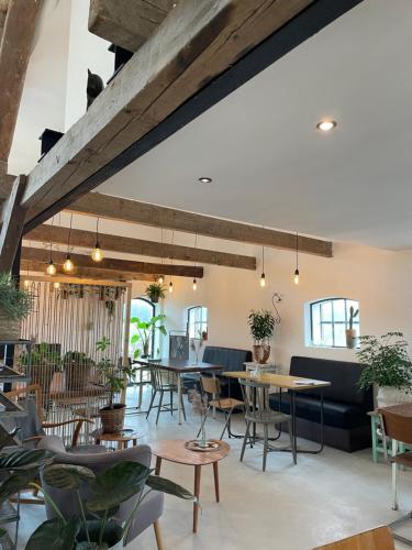 a restaurant with tables and chairs and a large ceiling at De Zuileshoeve in Dordrecht