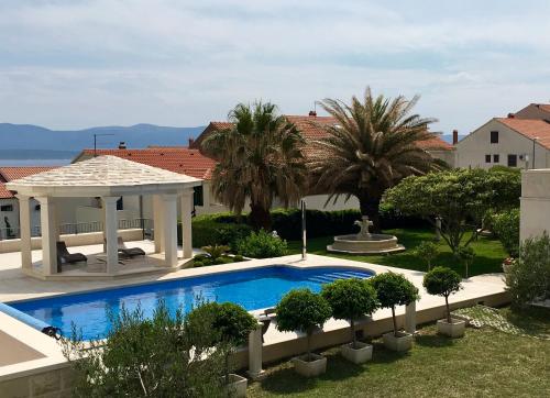 a swimming pool in a yard with a gazebo at Apartments Villa Jadranka Adults only in Bol