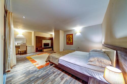 a bedroom with a bed and a living room at Апартаменти Свети Трифон in Pamporovo