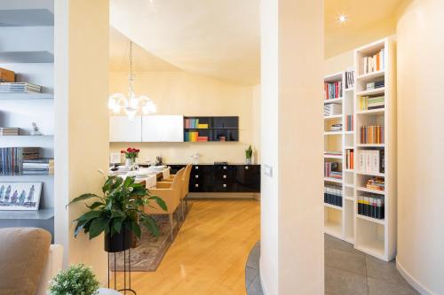 uma cozinha e sala de estar com prateleiras brancas em Foscolo 25 Apartment em Pisa
