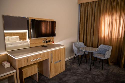 a hotel room with a desk and a bed at Classic Hotel in Al-ʿUla