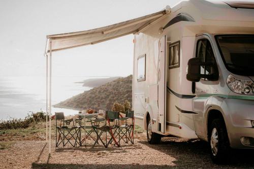 Camper for 4 persons Istria في بولا: مخيم بيض مع خيمة وكراسي