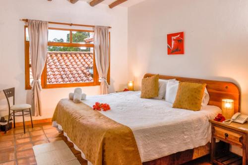 a bedroom with a large bed and a window at Casa de Campo Hotel & Spa in Villa de Leyva