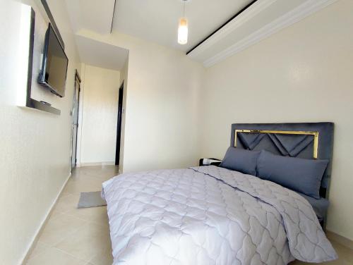 1 dormitorio con 1 cama grande con almohadas azules en Hotel La coline en Beni Mellal