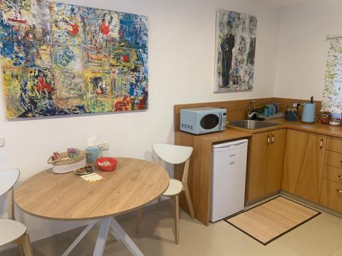 een kleine keuken met een tafel en een magnetron bij Iris privet room in Mevasseret Zion