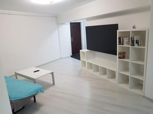 a living room with white shelves and a table at Rengo Residence in Târgovişte