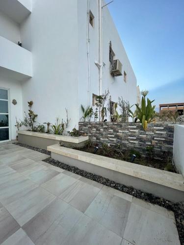 a white building with stairs and plants on it at La Casa Guest House in Marsa Alam City