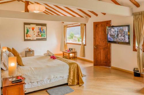 a bedroom with a large bed and a television at Casa de Campo Hotel & Spa in Villa de Leyva
