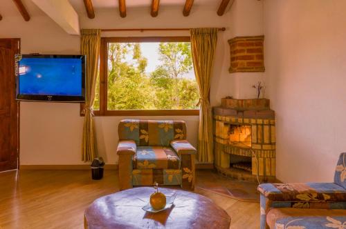 a living room with a large window and a tv at Casa de Campo Hotel & Spa in Villa de Leyva