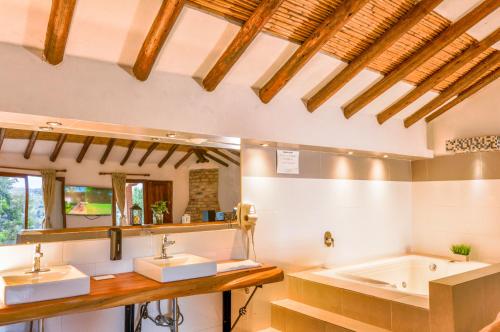 a bathroom with two sinks and a bath tub at Casa de Campo Hotel & Spa in Villa de Leyva