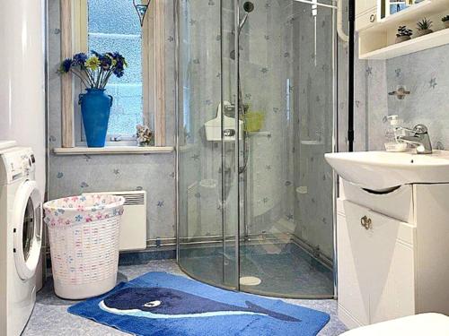 uma casa de banho com um chuveiro e um tapete azul em Holiday home SÖDERKÖPING II em Söderköping