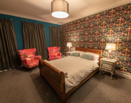 a bedroom with a bed and two chairs at The Angel of Bow in London