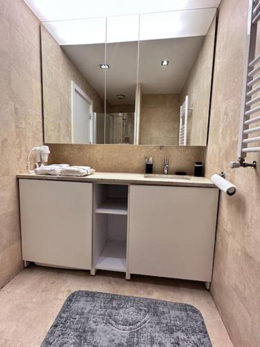 La salle de bains est pourvue d'un lavabo et d'un grand miroir. dans l'établissement Merkezi konumda şık daire, à Istanbul