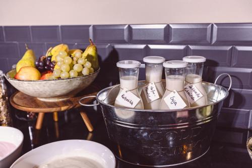 a bucket of candles and a bowl of fruit at Hotel Libertas elements pure in Freiburg im Breisgau