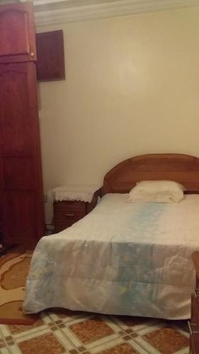 Appartement meublé في تمارة: غرفة نوم مع سرير وخزانة