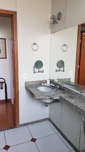 a bathroom with a sink in a white wall at Flat - Apart-hotel in Belo Horizonte