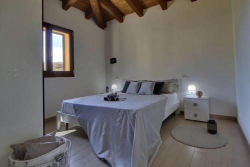 a bedroom with a bed with a table and a window at Casa Mediterraneo Lu Bagnu Castelsardo in Castelsardo