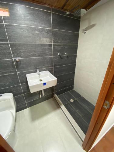 a bathroom with a sink and a toilet at CABAÑA LOS NOGALES in San Agustín