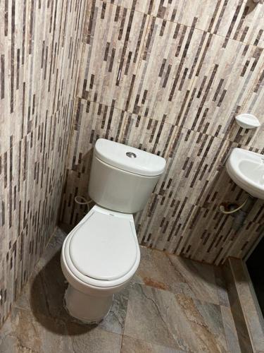 a bathroom with a white toilet and a sink at CABAÑA LOS NOGALES in San Agustín