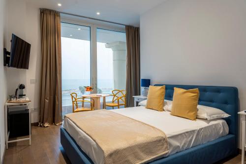 a bedroom with a blue bed with a view of the ocean at Crescent Moon in Salerno