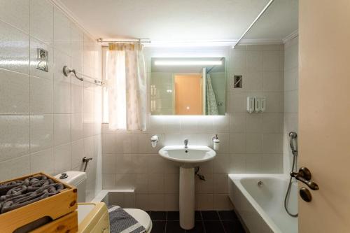 uma casa de banho com um lavatório, um WC e uma banheira em Kalamata Old City - Minimal Urban Retreat em Kalamata