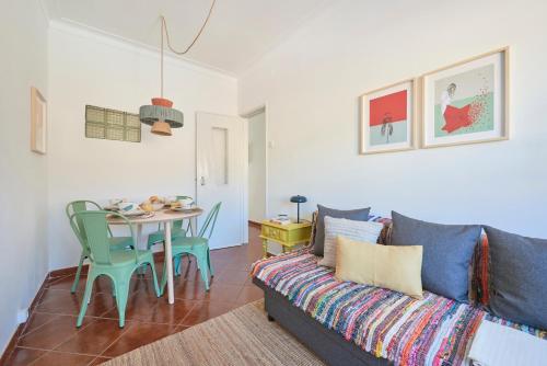 ein Wohnzimmer mit einem Sofa und einem Tisch in der Unterkunft Central & Sunny 2BR Apt Near Beach, By TimeCooler in Setúbal