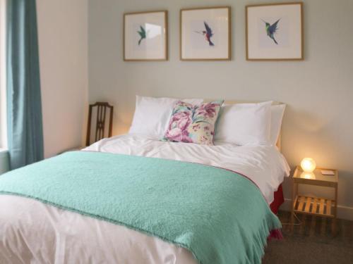 a bedroom with a bed with a green blanket on it at Devana Croft in Tarbert