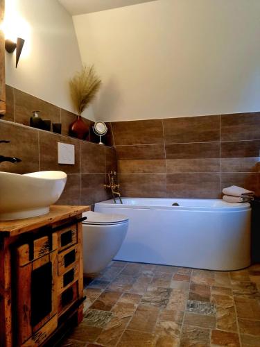 a bathroom with two sinks and a tub and a toilet at Haus Viking in Brodersby