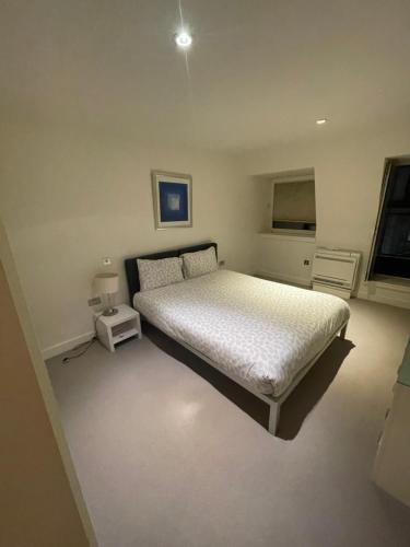 a bedroom with a white bed and a window at Oxford Street Apartment in London