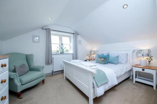 a bedroom with a white bed and a blue chair at Luxury Barn in North Scarle in North Scarle