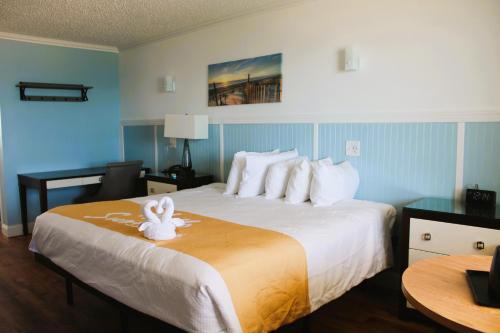 una habitación de hotel con una cama con un animal de toallas. en Blue Heron Motel en Nags Head